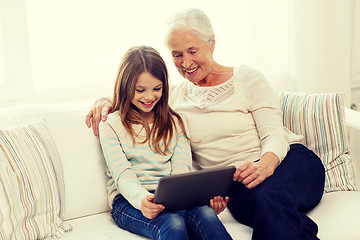 Image showing smiling family with tablet pc at home