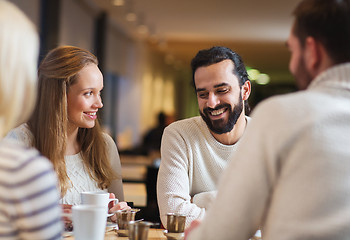 Image showing happy friends meeting and drinking tea or coffee