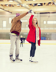 Image showing happy couple holding hands on skating rink