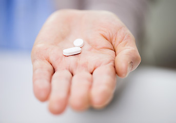 Image showing close up of senior woman hand with pills