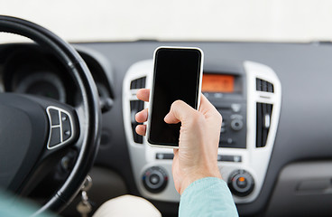 Image showing close up of man hand with smartphone driving car