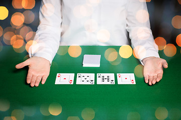 Image showing holdem dealer with playing cards over lights