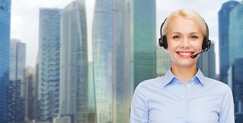 Image showing helpline operator in headset over city background