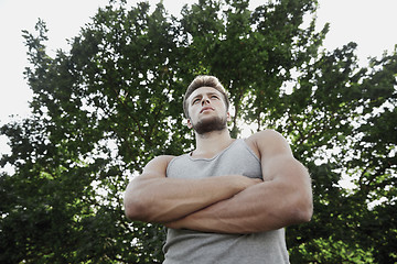 Image showing sporty young man with crossed arms at summer park