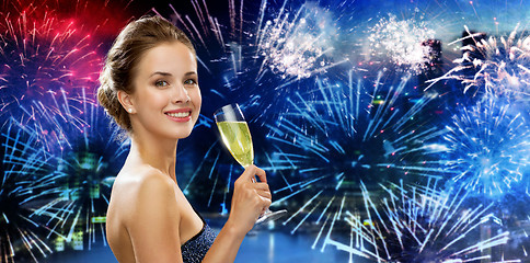 Image showing happy woman drinking champagne over firework