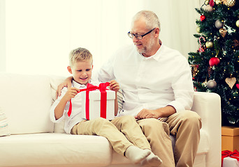 Image showing smiling grandfather and grandson with gift box