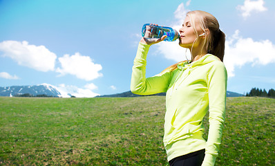 Image showing woman drinking water after doing sports outdoors