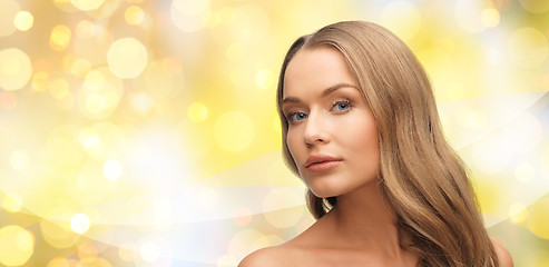Image showing beautiful young woman face over yellow lights