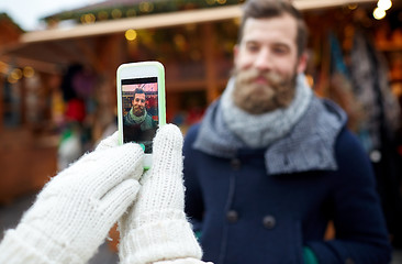 Image showing couple taking picture with smartphone in old town
