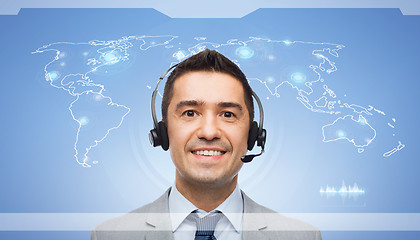 Image showing smiling businessman in headset over world map