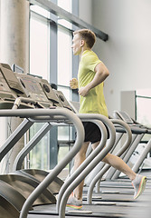 Image showing smiling man exercising on treadmill in gym