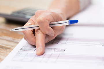 Image showing close up of senior woman hand checking bill