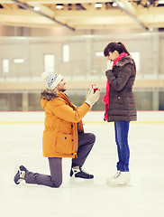 Image showing happy couple with engagement ring on skating rink