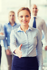 Image showing smiling businesswoman making handshake in office