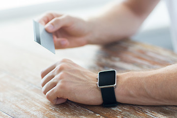 Image showing close up of hands with smart watch and credit card