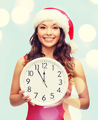 Image showing woman in santa helper hat with clock showing 12