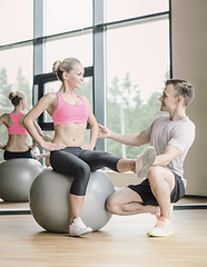 Image showing smiling man and woman with exercise ball in gym