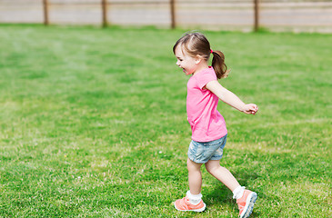 Image showing happy little girl running on green summer field