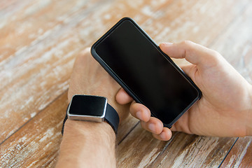 Image showing close up of hands with smart phone and watch