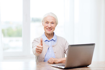 Image showing happy senior woman with laptop showing thumbs up