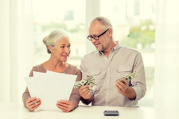 Image showing senior couple with money and calculator at home