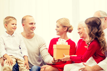 Image showing smiling family with gift at home