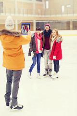 Image showing happy friends taking photo on skating rink
