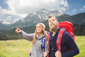 Image showing happy couple with backpacks hiking over mountains
