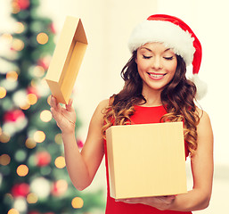 Image showing smiling woman in santa helper hat with gift box