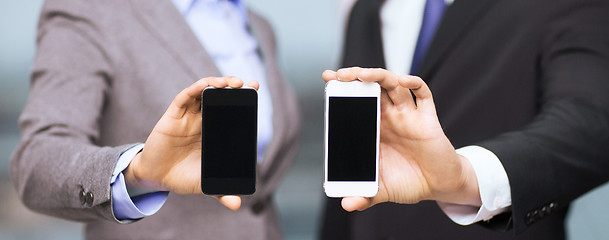 Image showing businessman and businesswoman with smartphones