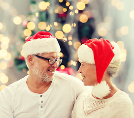 Image showing happy senior couple in santa helper hats