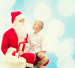 Image showing smiling little boy with santa claus and gifts