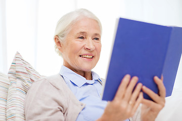 Image showing happy smiling senior woman reading book at home