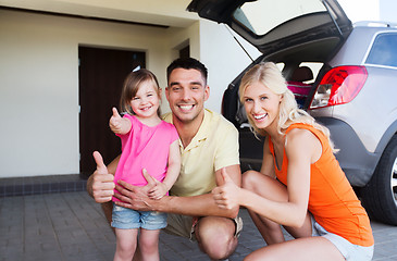 Image showing happy family with car showing thumbs up at parking