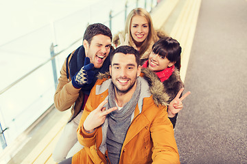 Image showing happy friends taking selfie on skating rink