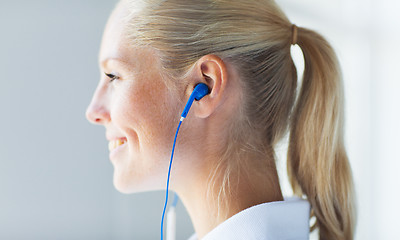 Image showing close up of happy woman in earphones at home