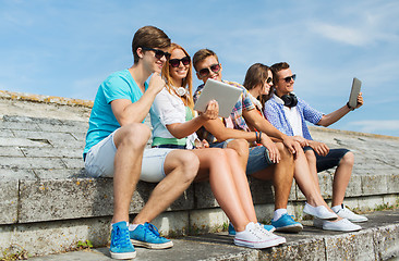 Image showing group of smiling friends with tablet pc outdoors