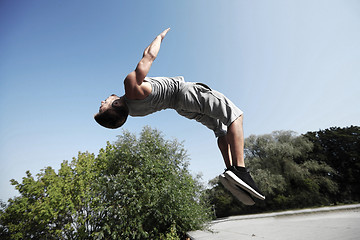 Image showing sporty young man jumping in summer park