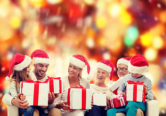 Image showing happy family in santa helper hats with gift boxes