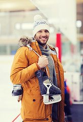 Image showing happy young man with ice-skates on skating rink