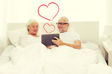 Image showing happy senior couple with tablet pc at home