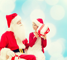 Image showing smiling little girl with santa claus and gifts