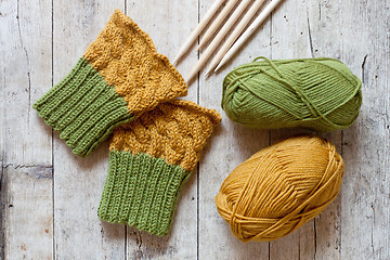 Image showing wool green and yellow legwarmers, knitting needles and yarn 