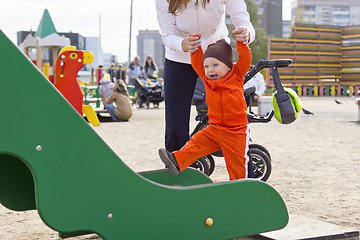 Image showing One year boy on children's slide with mother