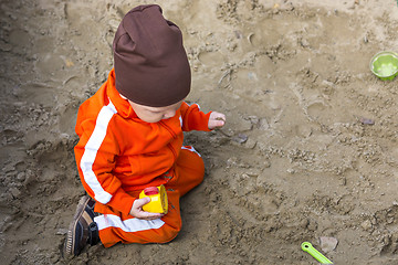 Image showing Baby boy is playing in sandbox