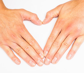 Image showing Adult person creating heart with hands towards grey white