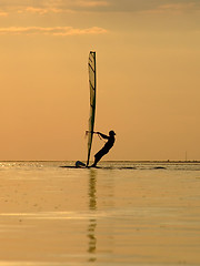 Image showing Silhouette of a wind-surfer on waves of a gulf on a sunset 1