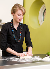 Image showing Young Woman Happily Making Pizza Dough