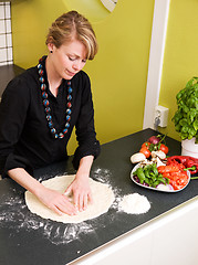 Image showing Young Woman Making Pizza Dough