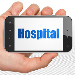 Image showing Health concept: Hand Holding Smartphone with Hospital on display